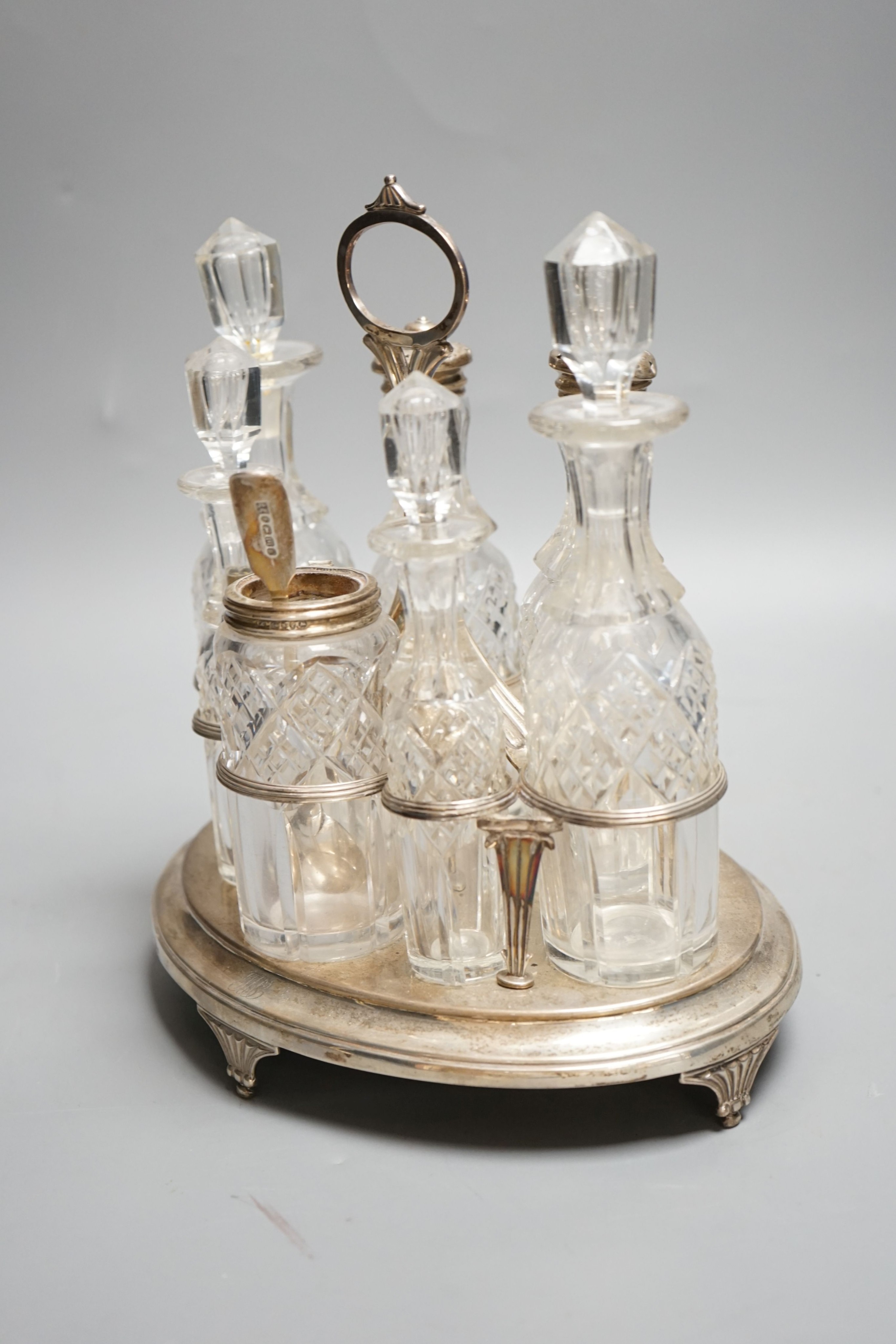 A George III silver oval cruet stand, Henry Nutting, London, 1805, height 25cm, 17.5oz, with six later associated glass bottles.